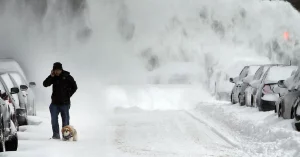 Man walking dog in snow storm