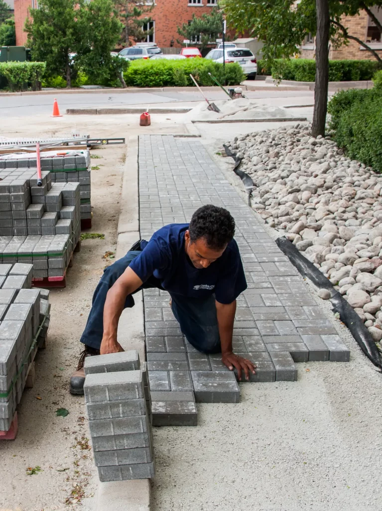 Worker laying down brick pathway
